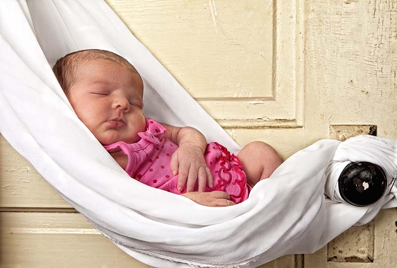 newborn baby sleeping in sling